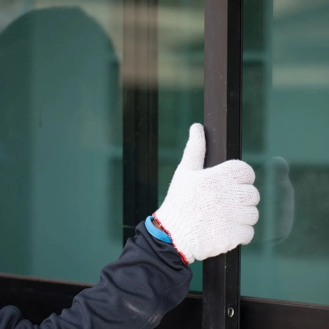 A person with gloves on is giving the thumbs up.